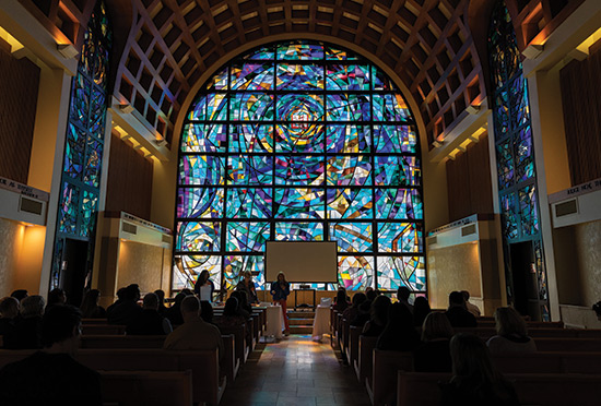 stain glass windows seen from inside the stauffer chapel as students worship