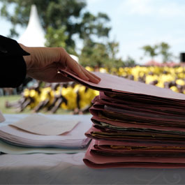 a stack of case files for inmates in a Uganda prison