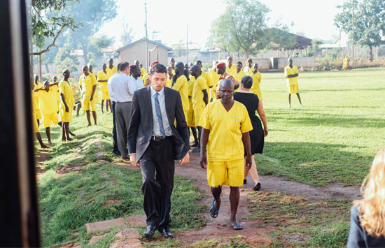 a lawyer walks with a man in a Ugandan prison