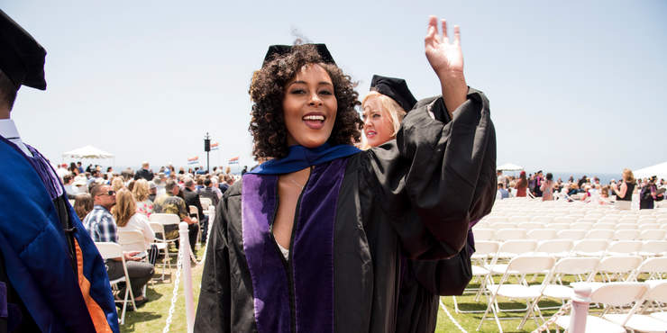 a female graduate student waving at Commencement 