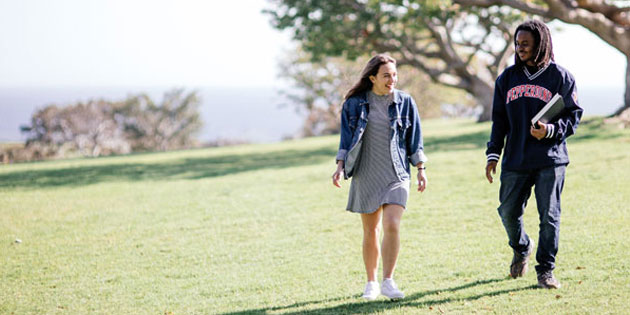 two students walk and talk across alumni park at Pepperdine 