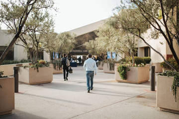 Two people seen from behind walking towards the Caruso School of Law building 