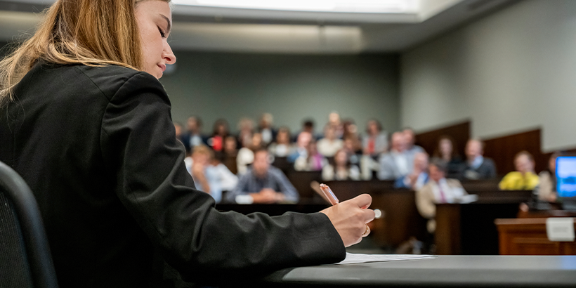 Lawyer writing notes in a courtroom