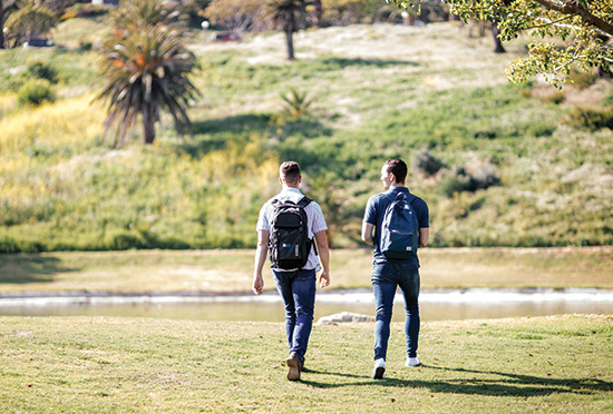 Two male law students walk across alumni park