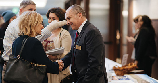 a man shaking a woman's hand in the School of Law atrium