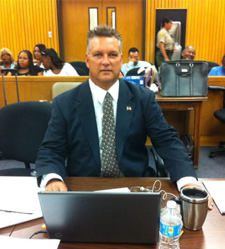 Charles Kilgore seated at a table with a laptop in a courtroom