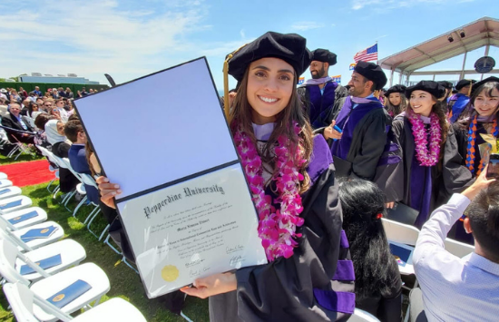 Ximena at graduation holding her diploma