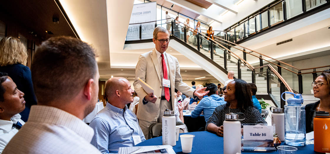 Dean Caron talking to a table of students at Launch Week in the atrium