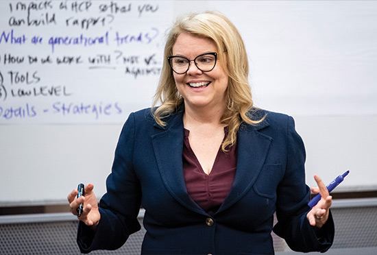 professor stephanie blondell gesturinig in front of a white board