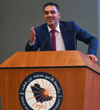 Muamar salameh speaking at a podium