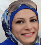 Noor head shot wearing blue scarf and glasses on head