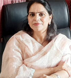 Rajinder wearing a pink shawl and sitting