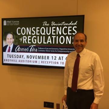 Ahmed Taha in front of conference digital sign