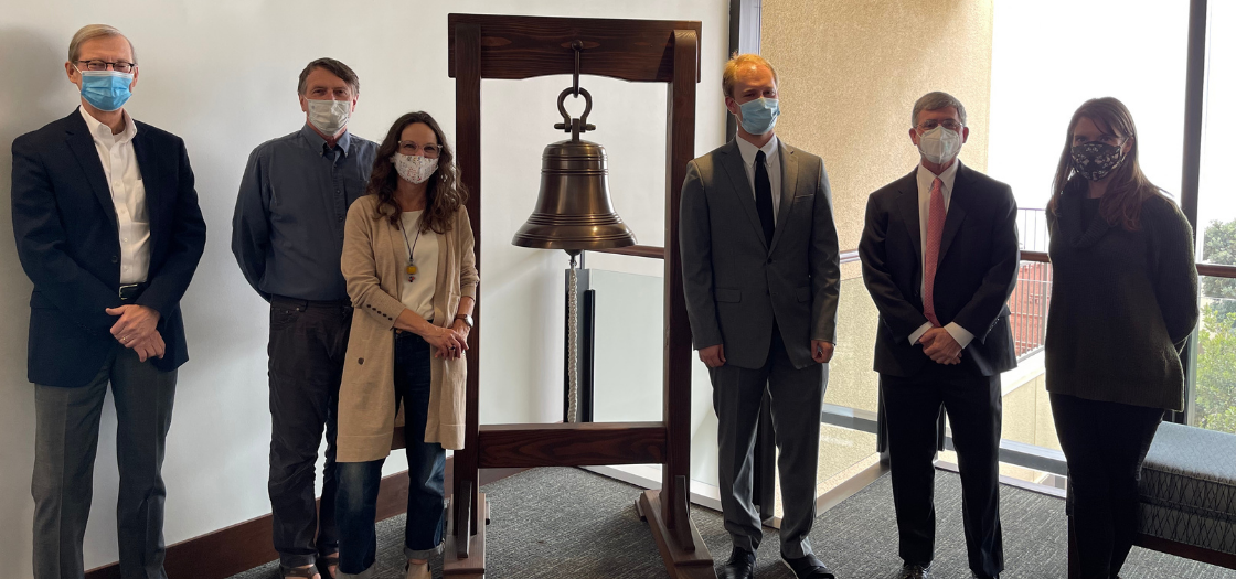 Nick Archibald stands with five professors around the bell