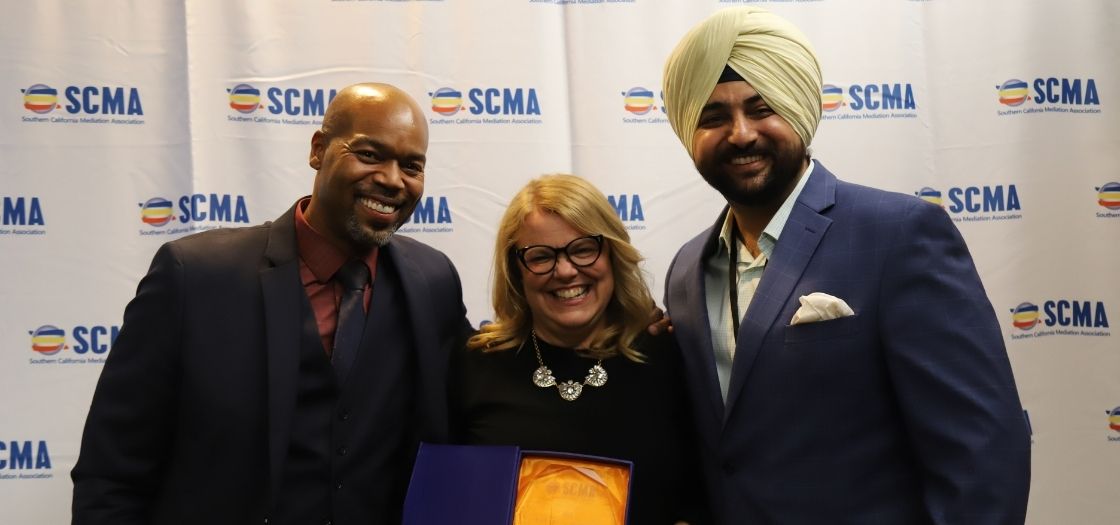 Professor Stephanie blondell holding an award between two people
