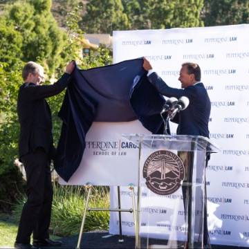 Paul Caron and Rick Caruso unveil sign with logo