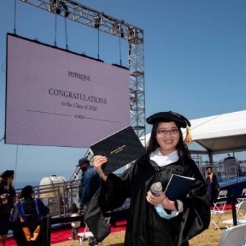 Photo of 2020 graduate with diploma at commencement