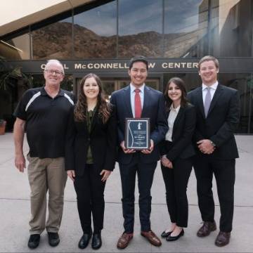 Trial competition team standing in front of law school