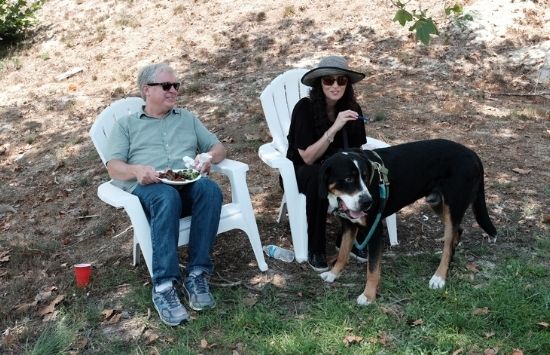 Professor Rick Cupp and his dog sitting at a BBQ