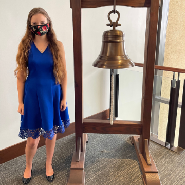 Elissa Crowder stands in front of the bell