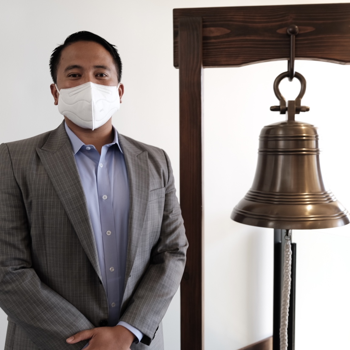 Joseph Castro standing next to the bell