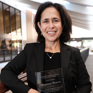 Maureen Weston at the School of Law holding her glass award 