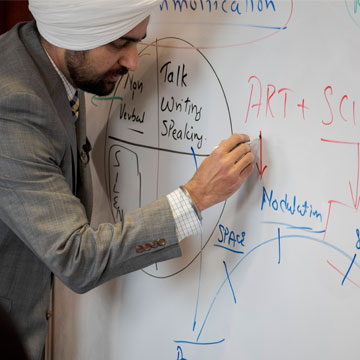 Professor Singh writing on a dry erase board