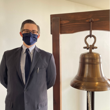 Michael Briggs standing next to a bell