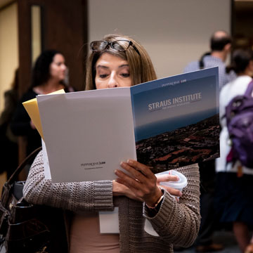 woman reading over a Straus brochure