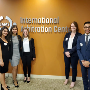 Five students stand in front of International Arbitration Center sign