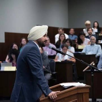 Sukhsimran Singh standing at podium