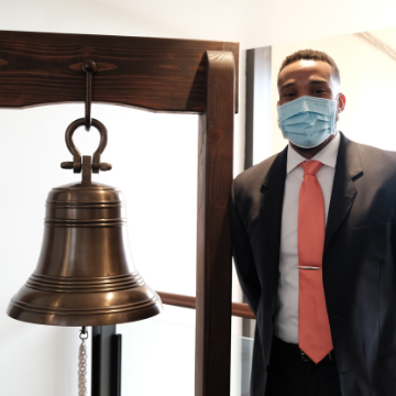 Thurgood Wynn stands next to the bell